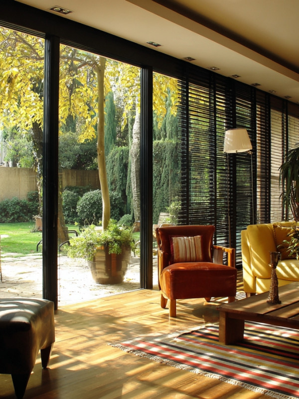 Sala elegante con piso laminado oscuro y persianas tipo madera