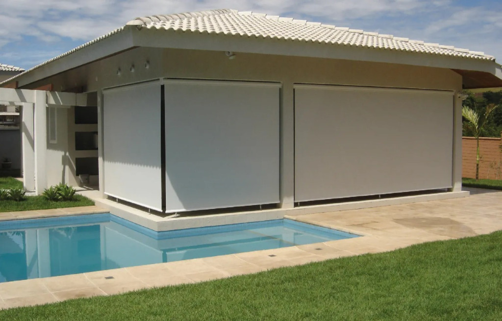 Toldo de caída libre vertical desplegado en ventana residencial para control solar y privacidad