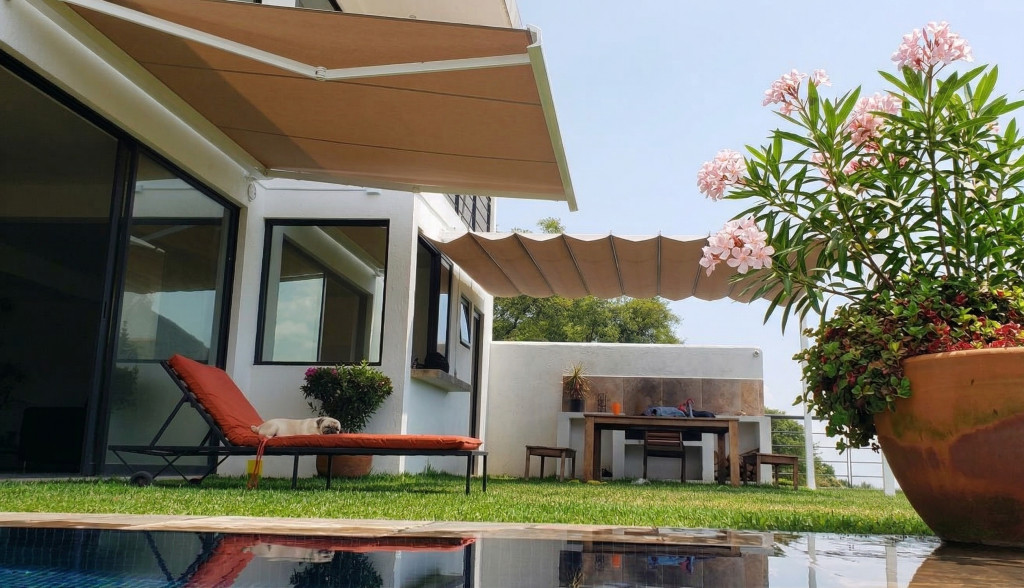 Techo retráctil con palillería plegable instalado en pérgola residencial creando sombra uniforme